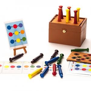 Arts Education. Photo of various playing cards, colored pegs, and a wooden box designed to help children learn about colors.