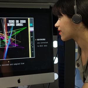 Interaction Design. Photo of a woman with headphones looking at a computer displaying an interactive User Experience.