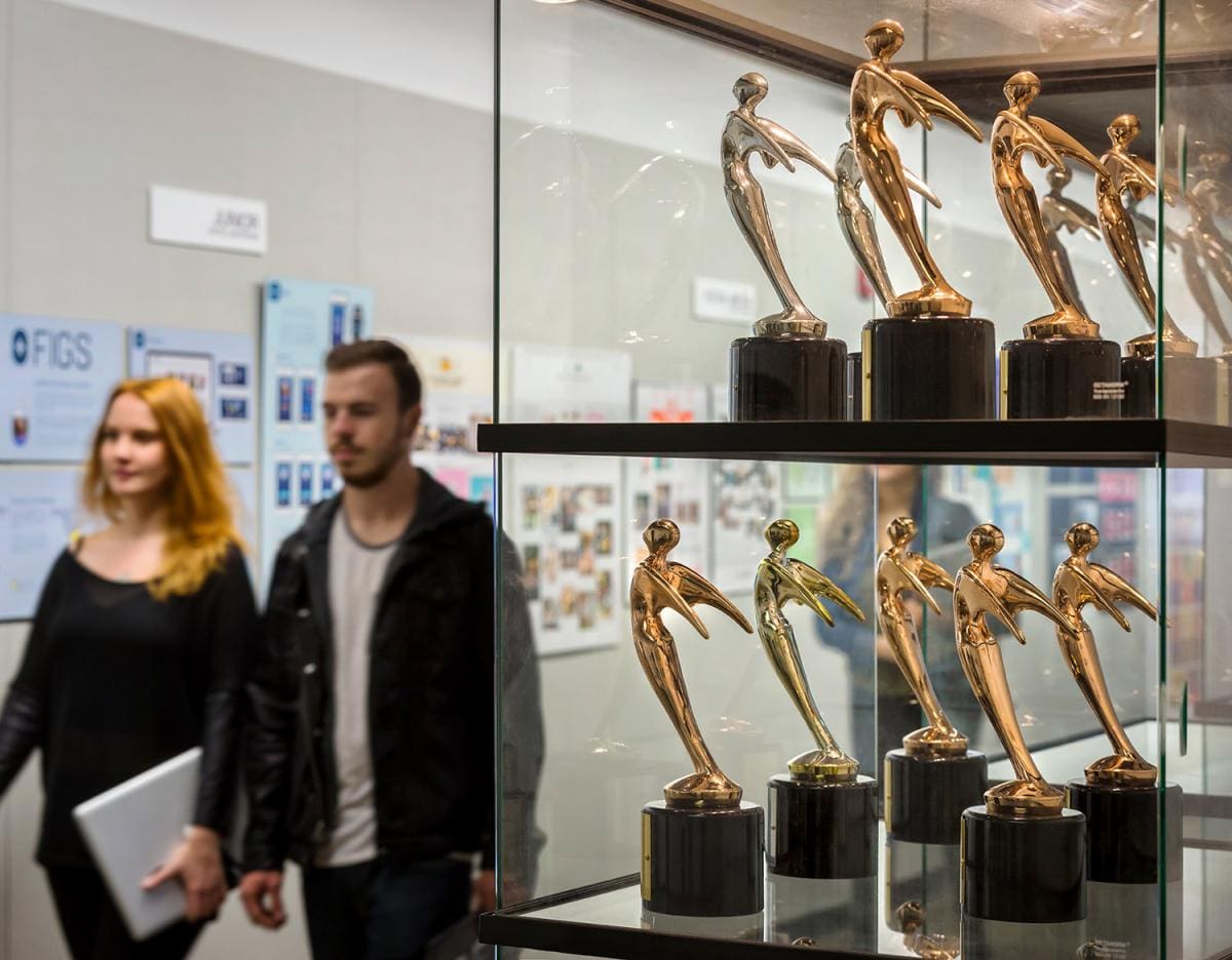 glass award case with gold statutes