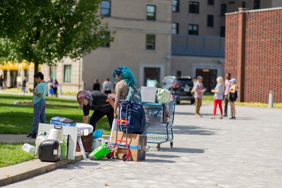 Photo of students and their families outside on the Ford Campus with dorm furniture on move-in day