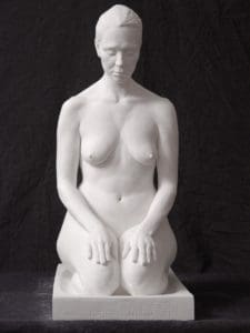 a woman with her eyes closed sitting on her feet