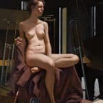 a seated nude woman posing in a figure drawing room
