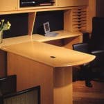 a office workstation with a wooden cabinets and an l-shaped desk