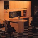 an office workstation with wooden cabinets