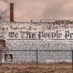 Faded and chipped mural of a newspaper on the side of an abandoned building