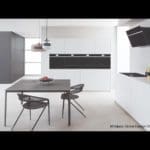 a modern kitchen with white cabinets and black appliances