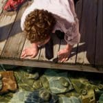 a figure on a dock looking into the water