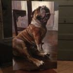 a bulldog sitting on a wooden floor