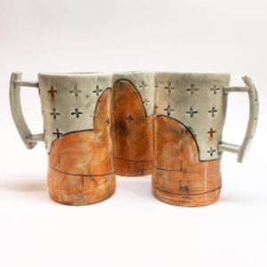 repeating plus signs on orange and cream colored mugs