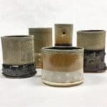 five brown and green ceramic cups