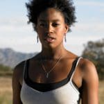 a portrait of a woman of color wearing a white tank top